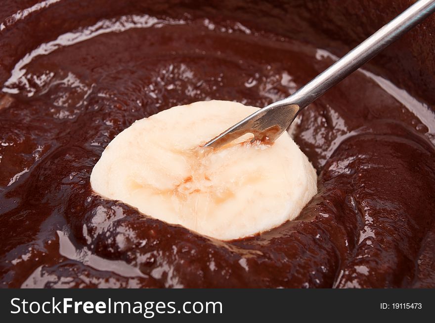 Delicious chocolate fondue with banana macro background