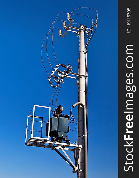 Transformer station placed on concrete electricity pole over blue sky. Transformer station placed on concrete electricity pole over blue sky.