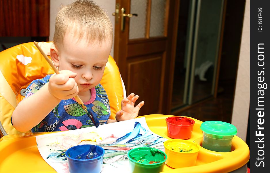 Little boy draws a colorful paints and brushes. Little boy draws a colorful paints and brushes