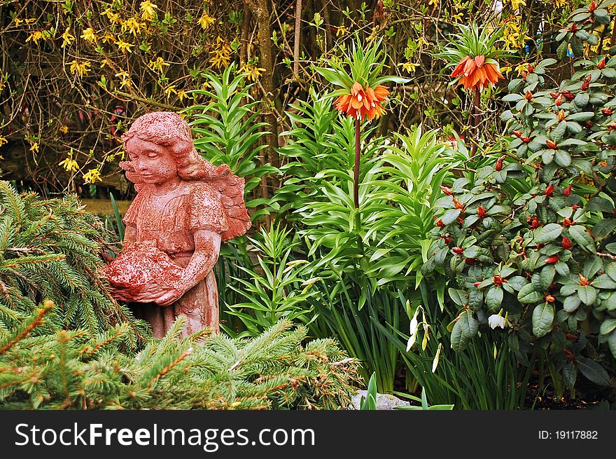 Ornamental fairy in lush garden setting. Ornamental fairy in lush garden setting