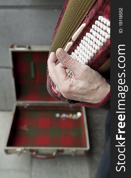 Street performer playing music on a vintage accordion squeeze box. Street performer playing music on a vintage accordion squeeze box