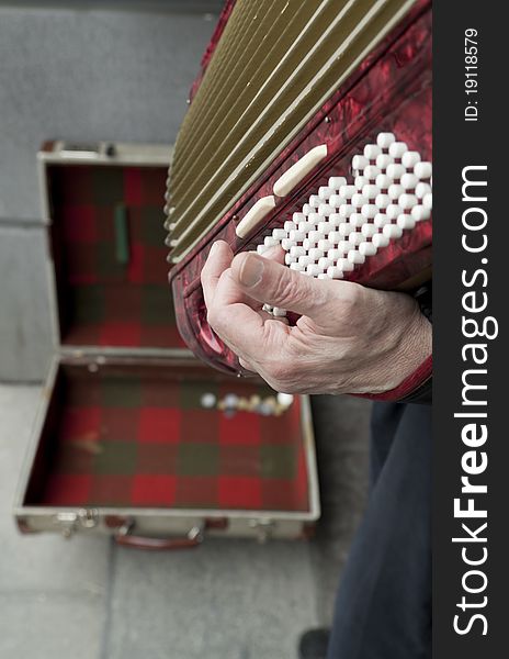 Street performer playing music on a vintage accordion squeeze box. Street performer playing music on a vintage accordion squeeze box