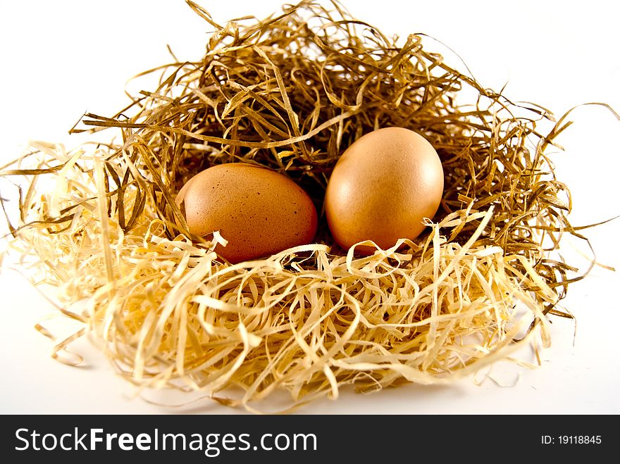 Two eggs lying on the straw of which may appear chickens