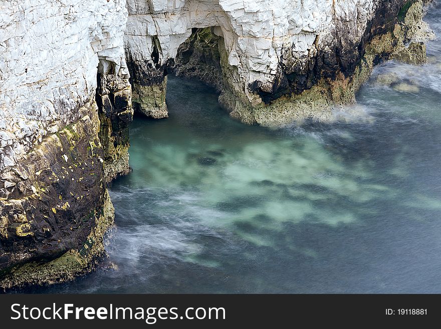 A long exposure of the sea around the bottom of a chalk cliff. Taken in the Jurassic Coast of Dorset. A long exposure of the sea around the bottom of a chalk cliff. Taken in the Jurassic Coast of Dorset.