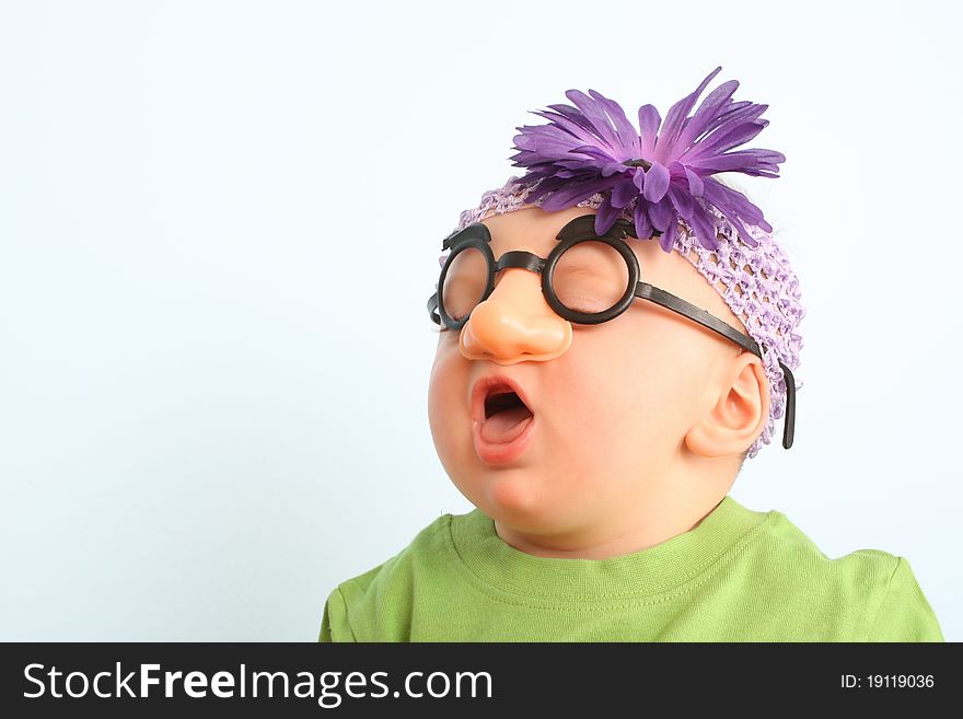 Funny baby wearing toy glasses and headband