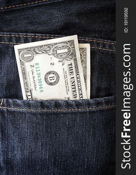 Dollars in a jeans pocket vertical