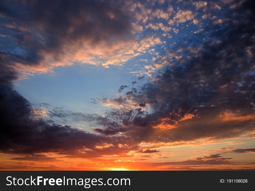 Sunset in the colorful clouds, orange and blue sky at sunset. Sunset in the colorful clouds, orange and blue sky at sunset