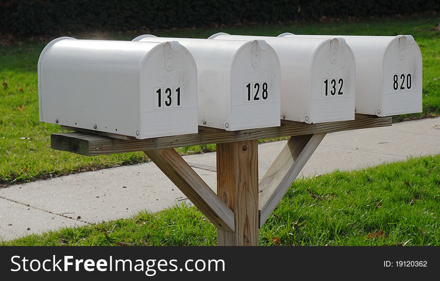 White Mailboxes In A Row With Sidewalk