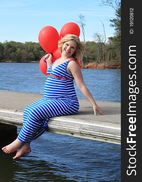Beautiful pregnant woman on a wooden dock. Beautiful pregnant woman on a wooden dock.