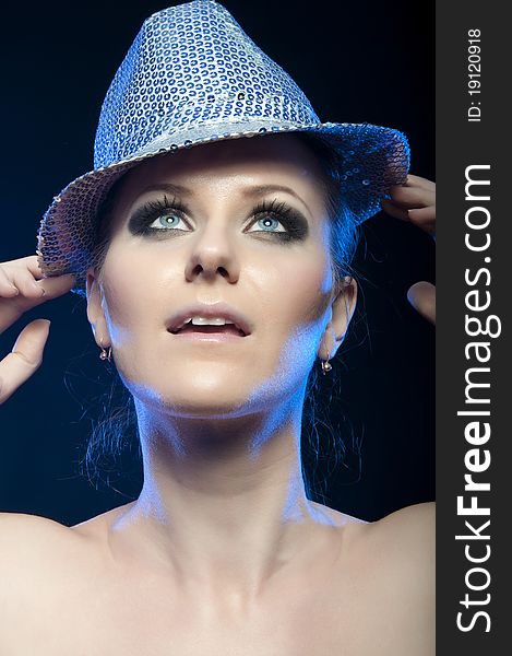 Portrait of a beautiful young girl in a silver disco hat