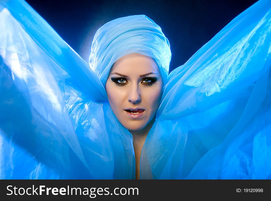 Portrait of a beautiful young girl in a blue veil with beautiful eyes