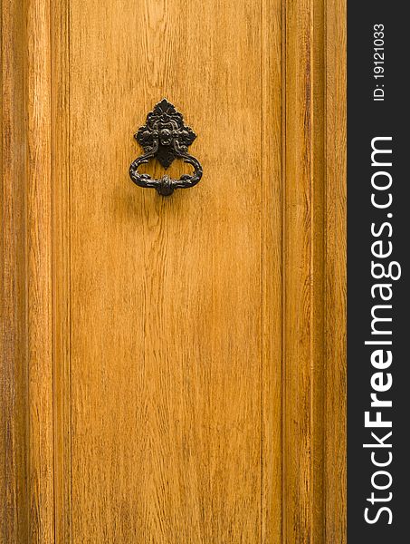 Closeup image of old door with iron handle/knocker