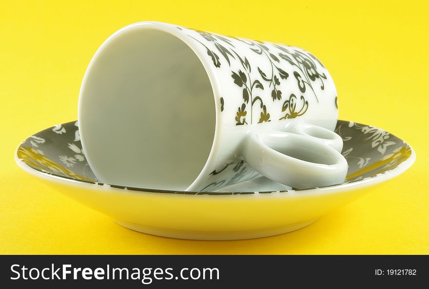 Cup and saucer isolated over yellow background. Cup and saucer isolated over yellow background