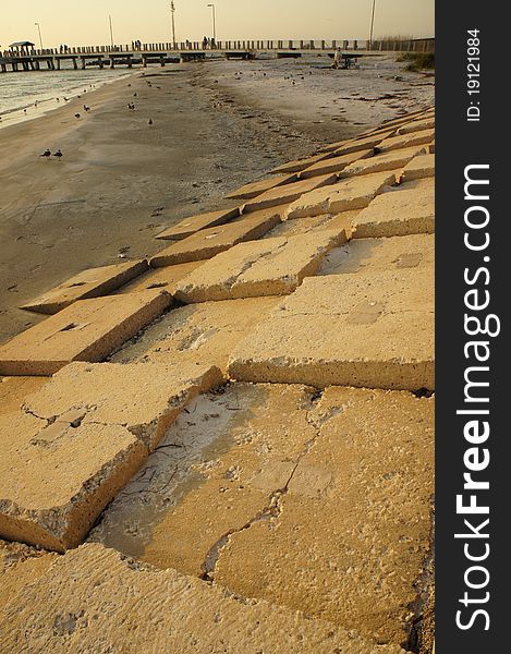 Picture of a sea wall with a pier in the background