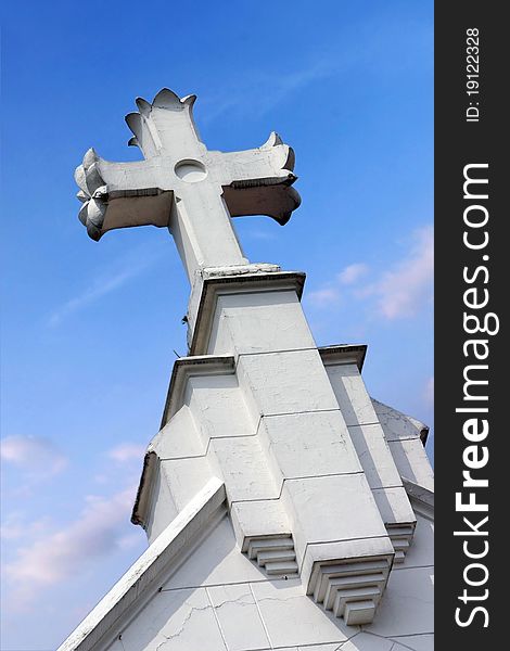 Crucifix towered above the church on blue sky