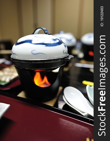 Japanese mini hotpot onto a small stove with fire. Japanese mini hotpot onto a small stove with fire