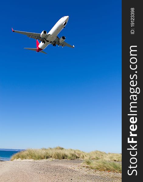 Low airplane coming in to land over Seven Mile Beach, Tasmania.