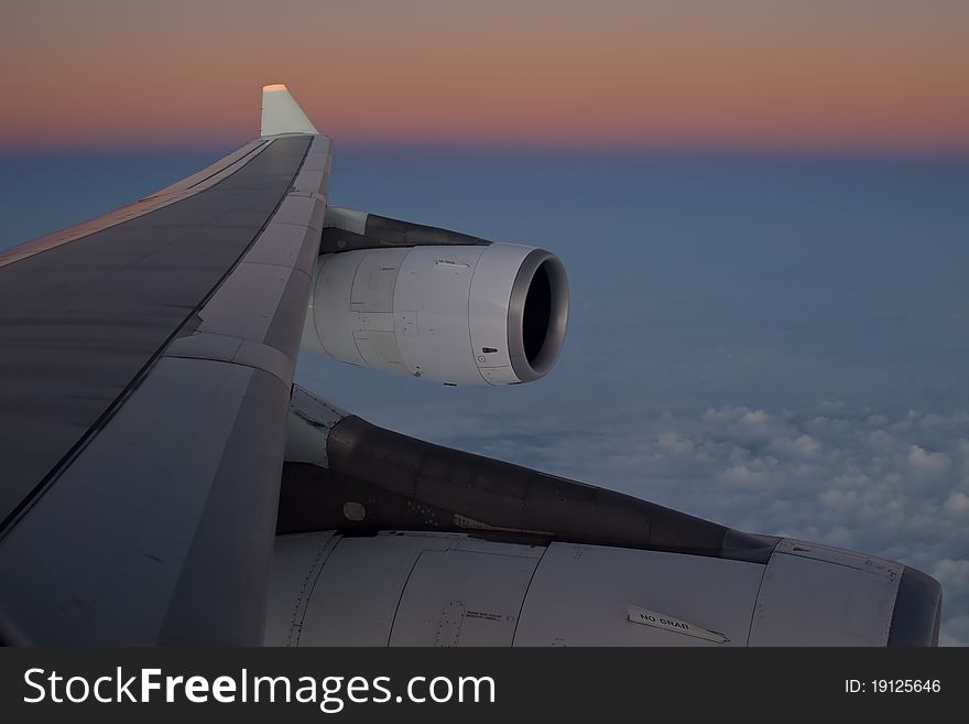 Aircraft wing seen at cruising level at dusk