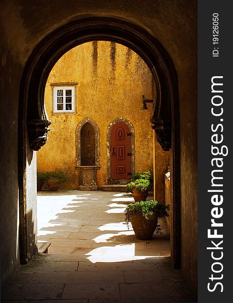 View of a courtyard of the palace of the penalty through a stone arch. View of a courtyard of the palace of the penalty through a stone arch