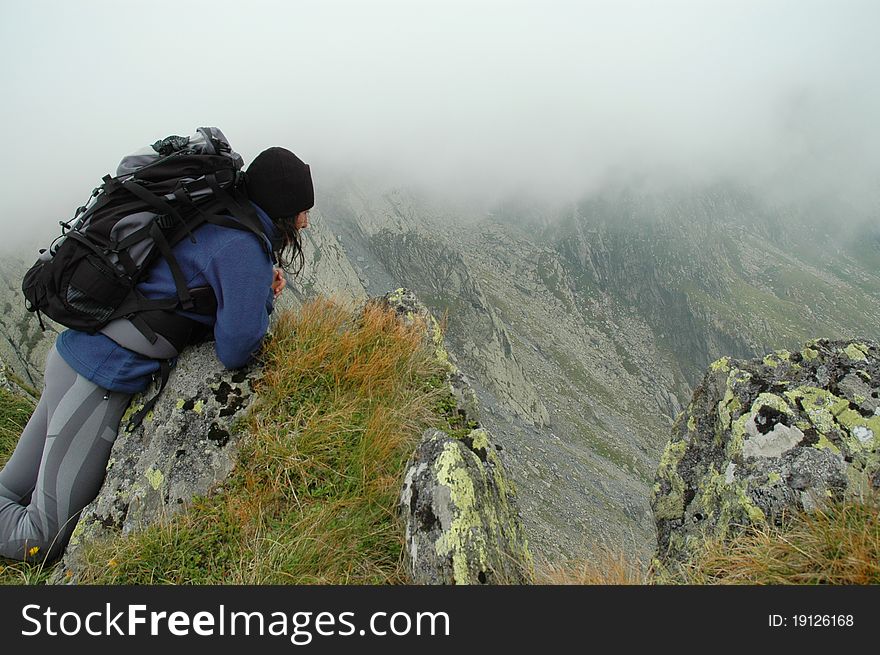 Girl Sitting On The Top Of A Mountain