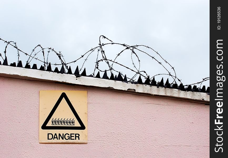 Razor wire and danger sign with plain areas suitable for text. Razor wire and danger sign with plain areas suitable for text