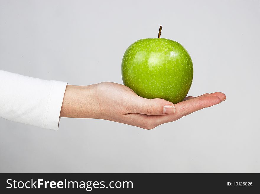 Green healthy apple in woman hand isolated on white background. Green healthy apple in woman hand isolated on white background