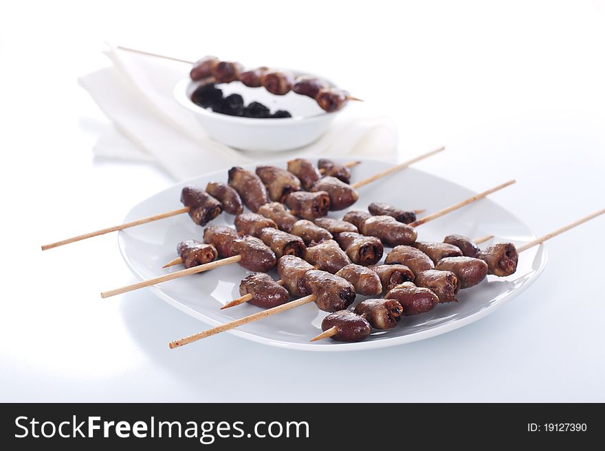 Grilled chicken hearts on skewers with soy sauce and salad.