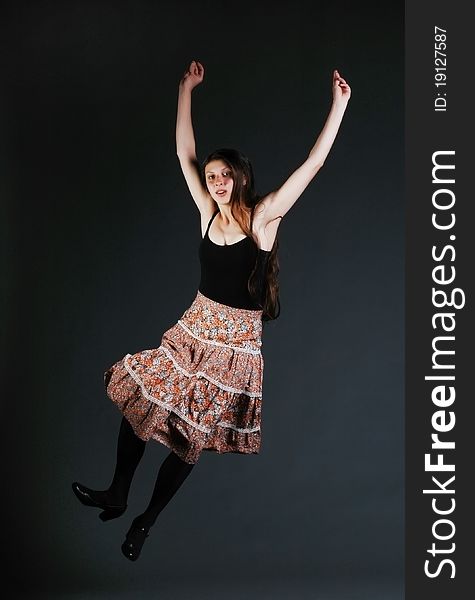 Dancing girl with colored skirt jumping