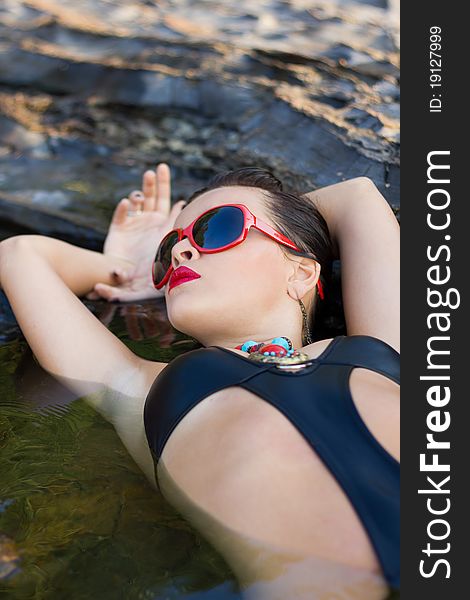 Overhead portrait of attractive young woman with makeup relaxing in sea or rock pool. Overhead portrait of attractive young woman with makeup relaxing in sea or rock pool.