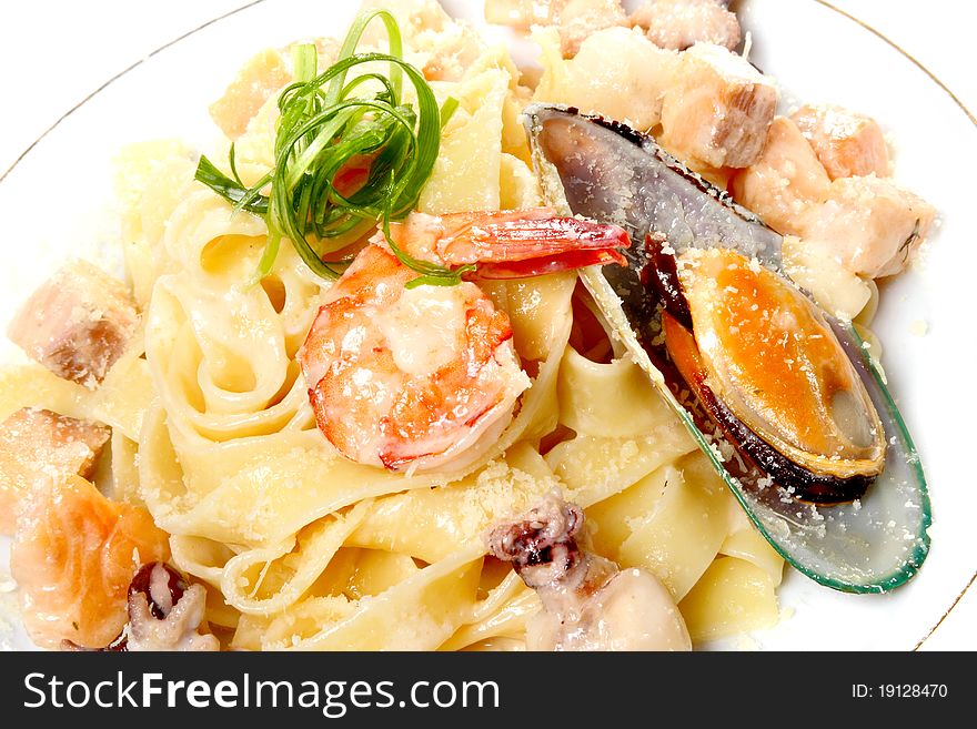 Spaghetti on a plate with cheese parmesan, sauce and seafood