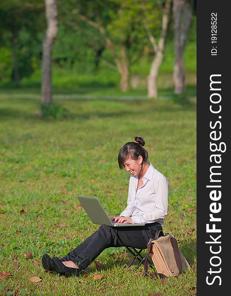 Business woman staying connected while out in the park. Business woman staying connected while out in the park