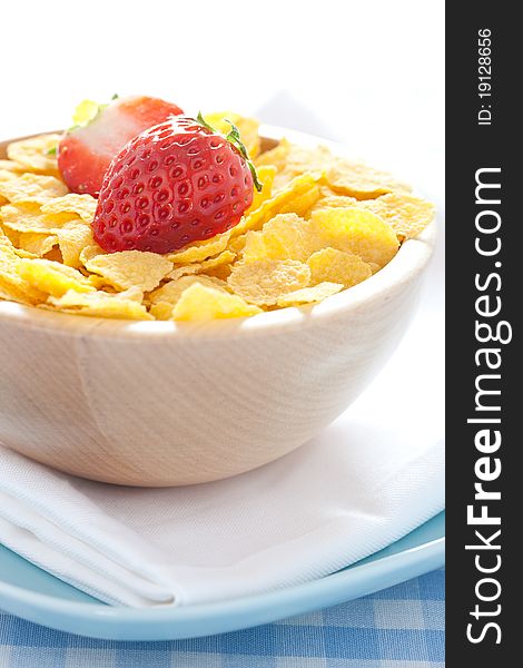 Fresh cornflakes in a bowl with strawberries