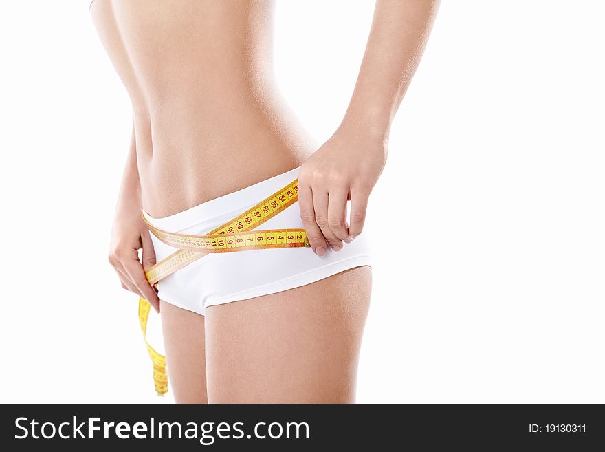 Young girl measuring hip on a white background. Young girl measuring hip on a white background