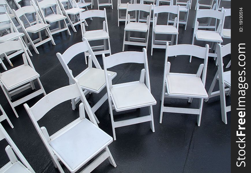 Several white plastic chairs on gray floor. Several white plastic chairs on gray floor