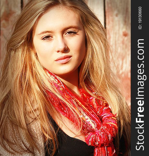 A girl/woman with a red scarf and brown eyes looking relaxed in the warm sunshine. A girl/woman with a red scarf and brown eyes looking relaxed in the warm sunshine