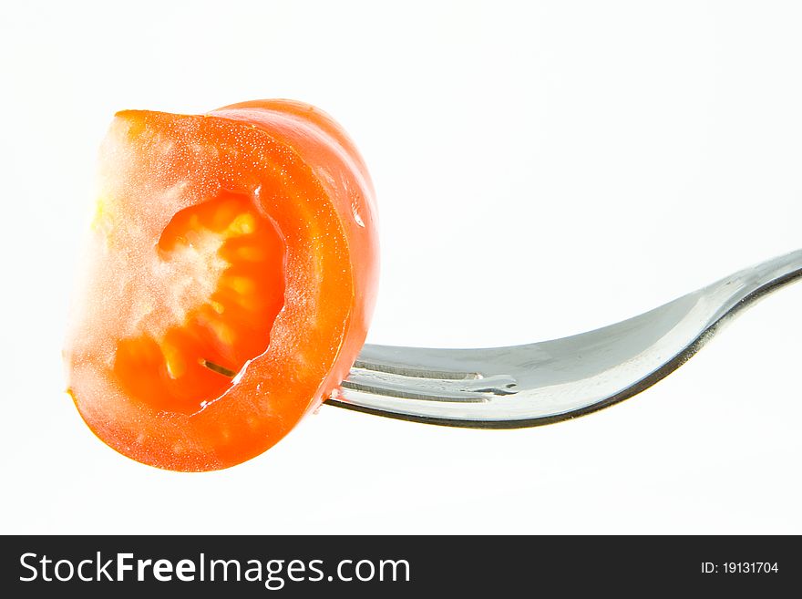 A Tomato on a fork with a white background