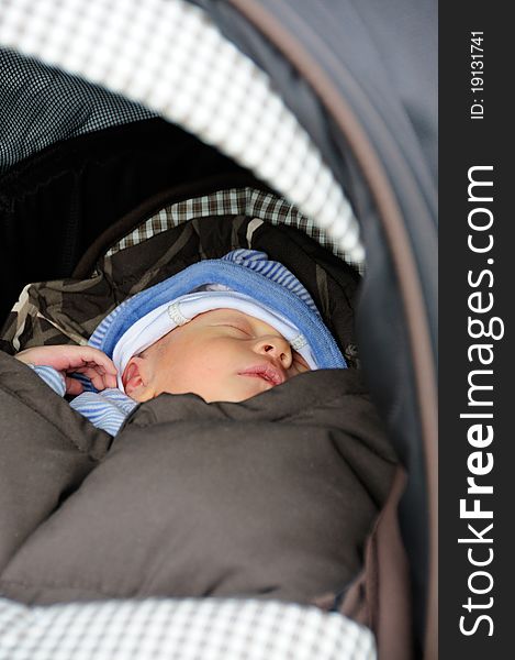 Cute new born baby sleeping in his buggy. Cute new born baby sleeping in his buggy.