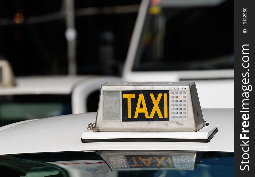 Yellow taxi sign on a roof of taxi car waiting in a queue.