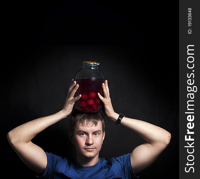 Young man with a balloon conserved plums. Isolated on a black background. Young man with a balloon conserved plums. Isolated on a black background