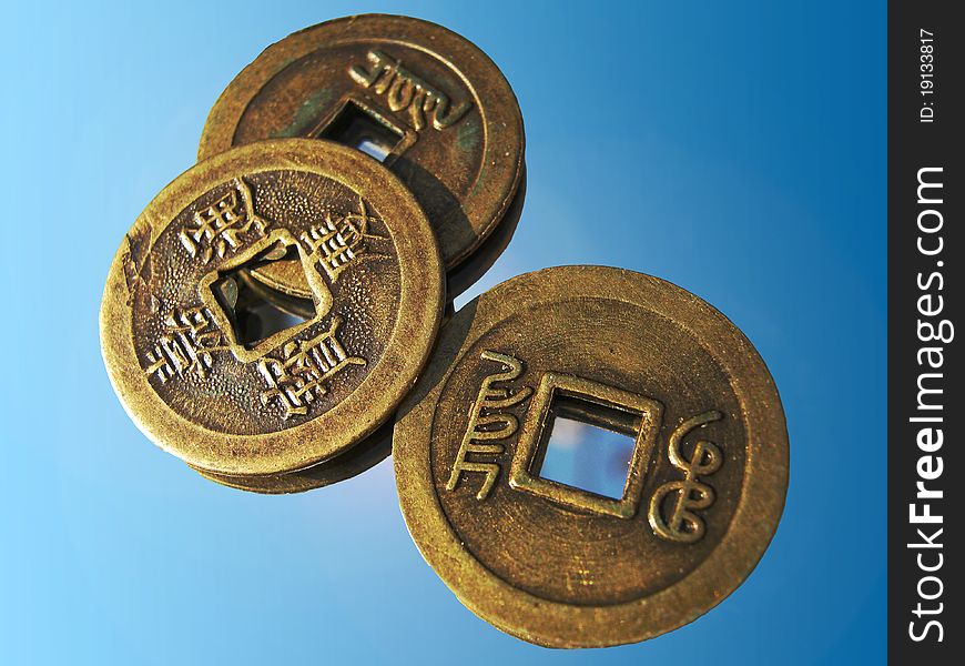 Three shining chinese luck coins from 18. Century on a mirror. Three shining chinese luck coins from 18. Century on a mirror