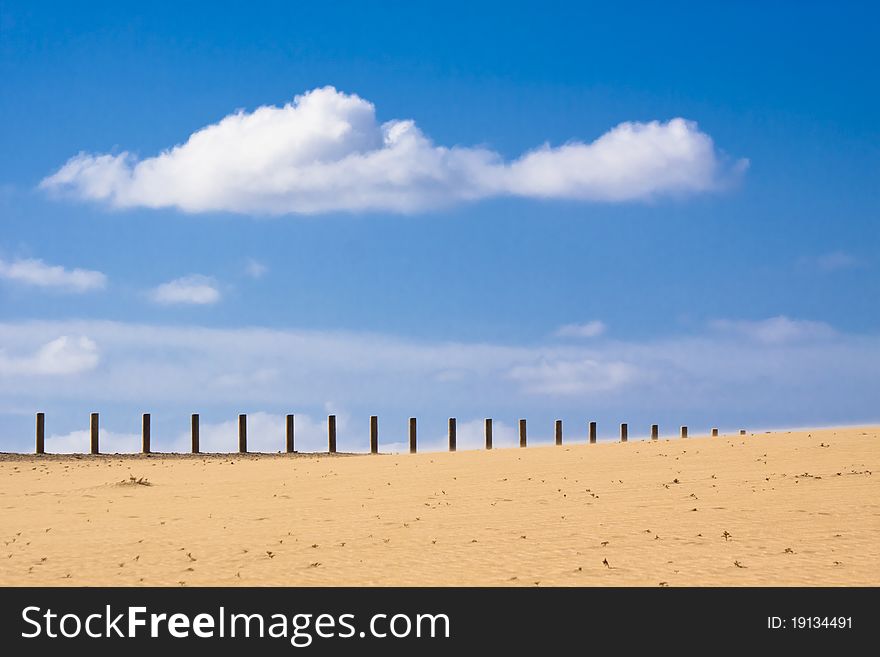 Wooden fence dissapearing into the infinity of the dessert.