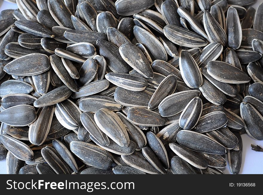 Sunflower seeds on white background, with selective focus on the foreground