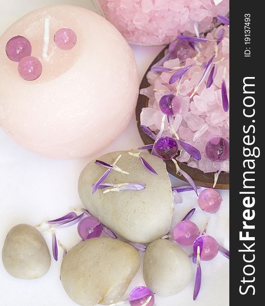 With purple floral petals and stones. With purple floral petals and stones