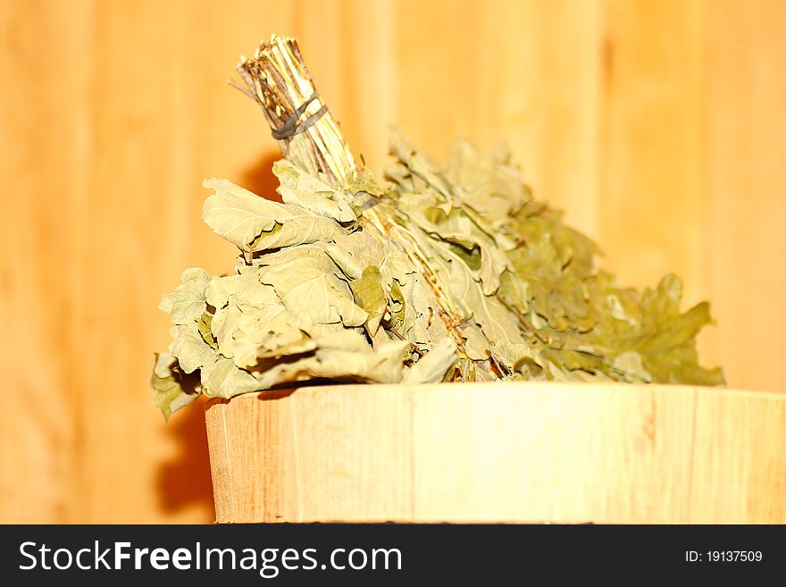 Oak broom in a basin on a background bath. Oak broom in a basin on a background bath