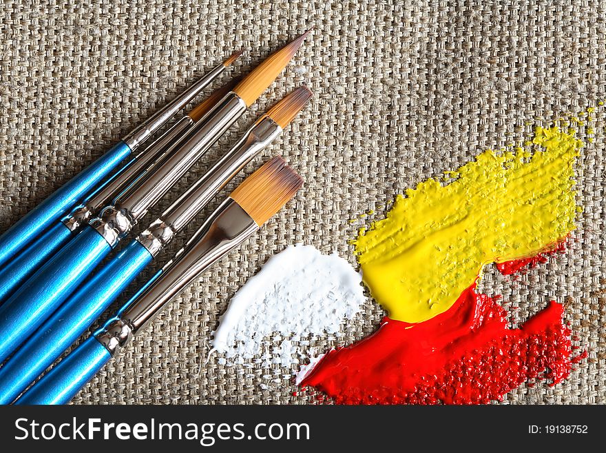 Set of paintbrushes and color paint on canvas background. Set of paintbrushes and color paint on canvas background