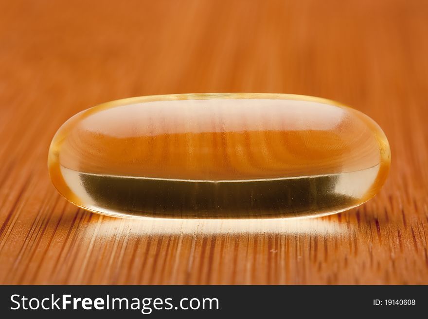 Medical pill against diseases on a wooden table.