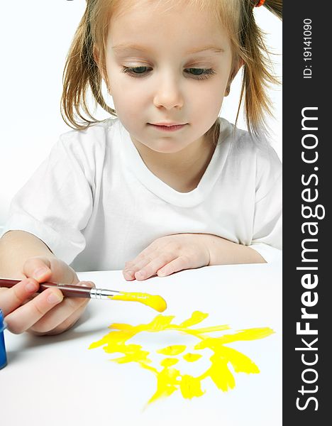 Cute little girl with a brush and paints