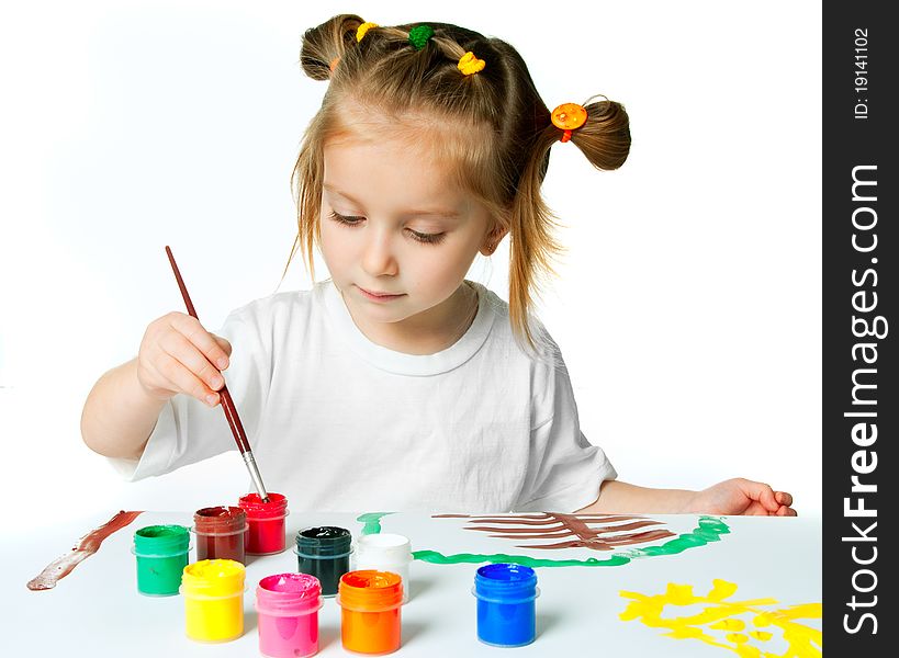 Cute little girl with a brush and paints