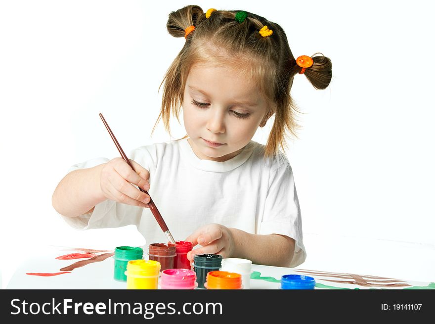 Cute little girl with a brush and paints