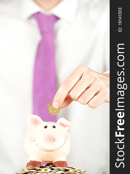 Businessman saving money on a piggy bank